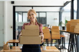 Happy Woman Holding Shipping Boxes In A Workplace 2026 01 07 00 21 38 Utc1