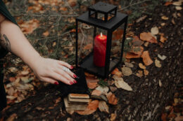Kéz tarot-kártyákkal és lámpással
